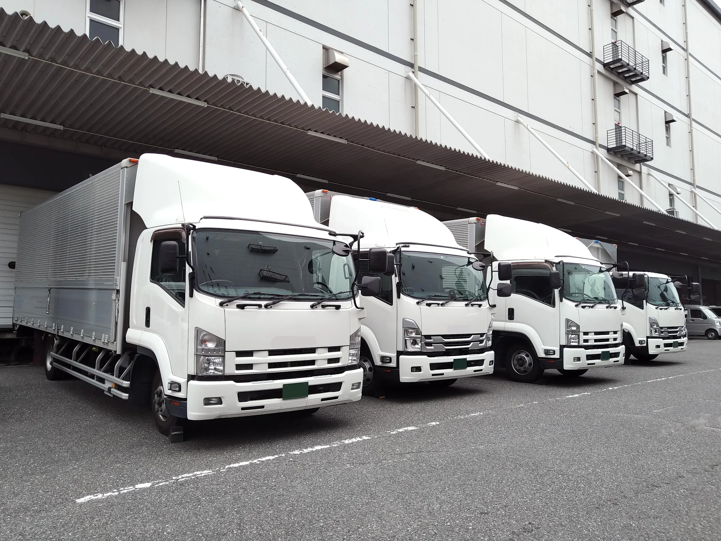 倉庫の前に並んだ事業用トラック
